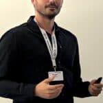 Giulio Sironi standing with a badge at Skyquest event.