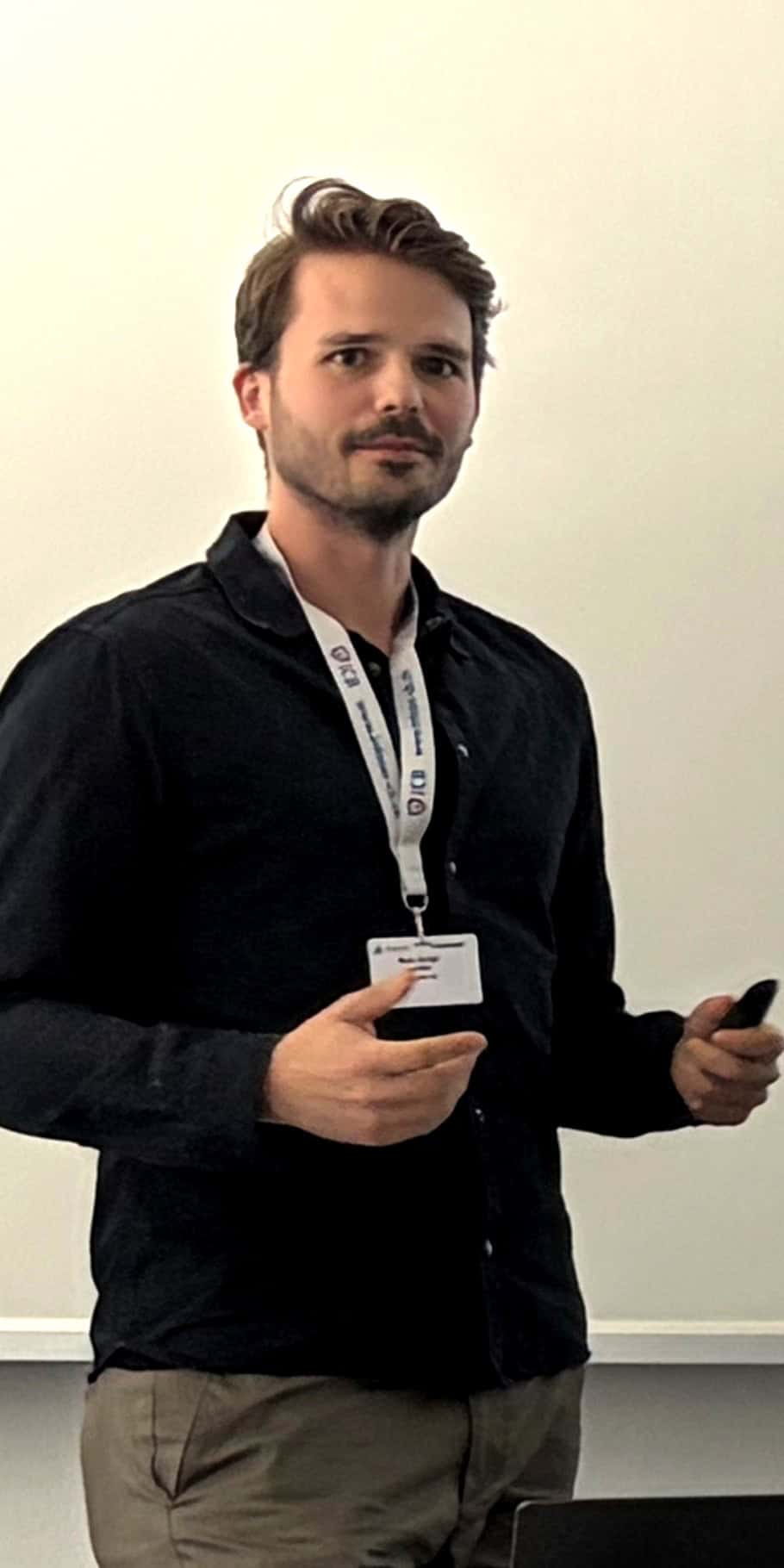 Giulio Sironi standing with a badge at Skyquest event.